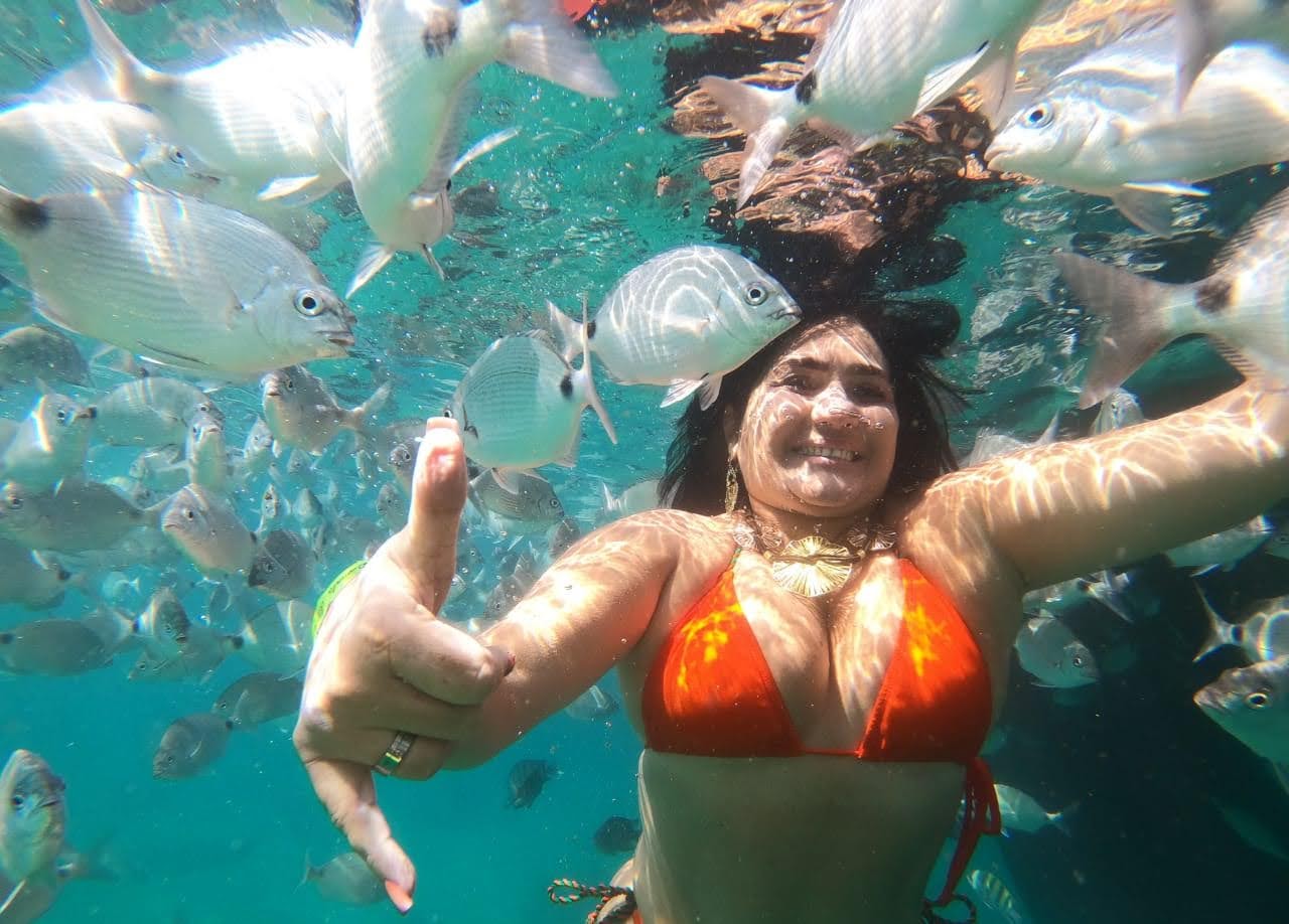 Ana Maria embaixo d'água rodeada de peixes